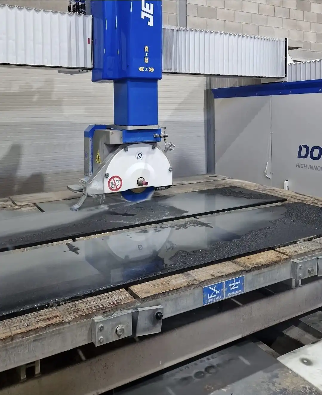 Disc de tall refrigerat per aigua tallant una llosa de granit negre