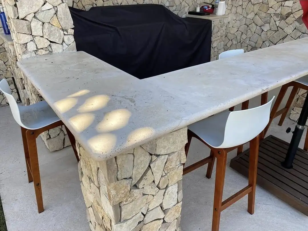 Barra de barbacoa en travertí sobre mur de pedra seca