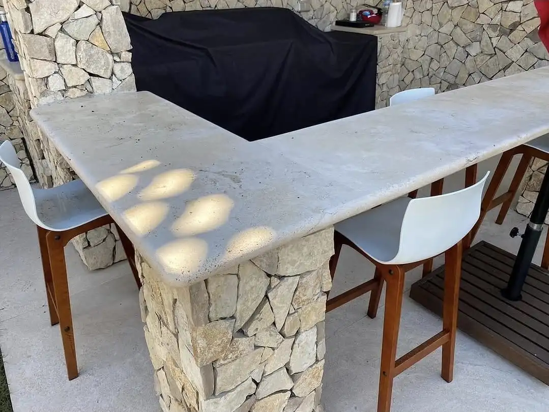 Barra de barbacoa en travertí sobre mur de pedra seca