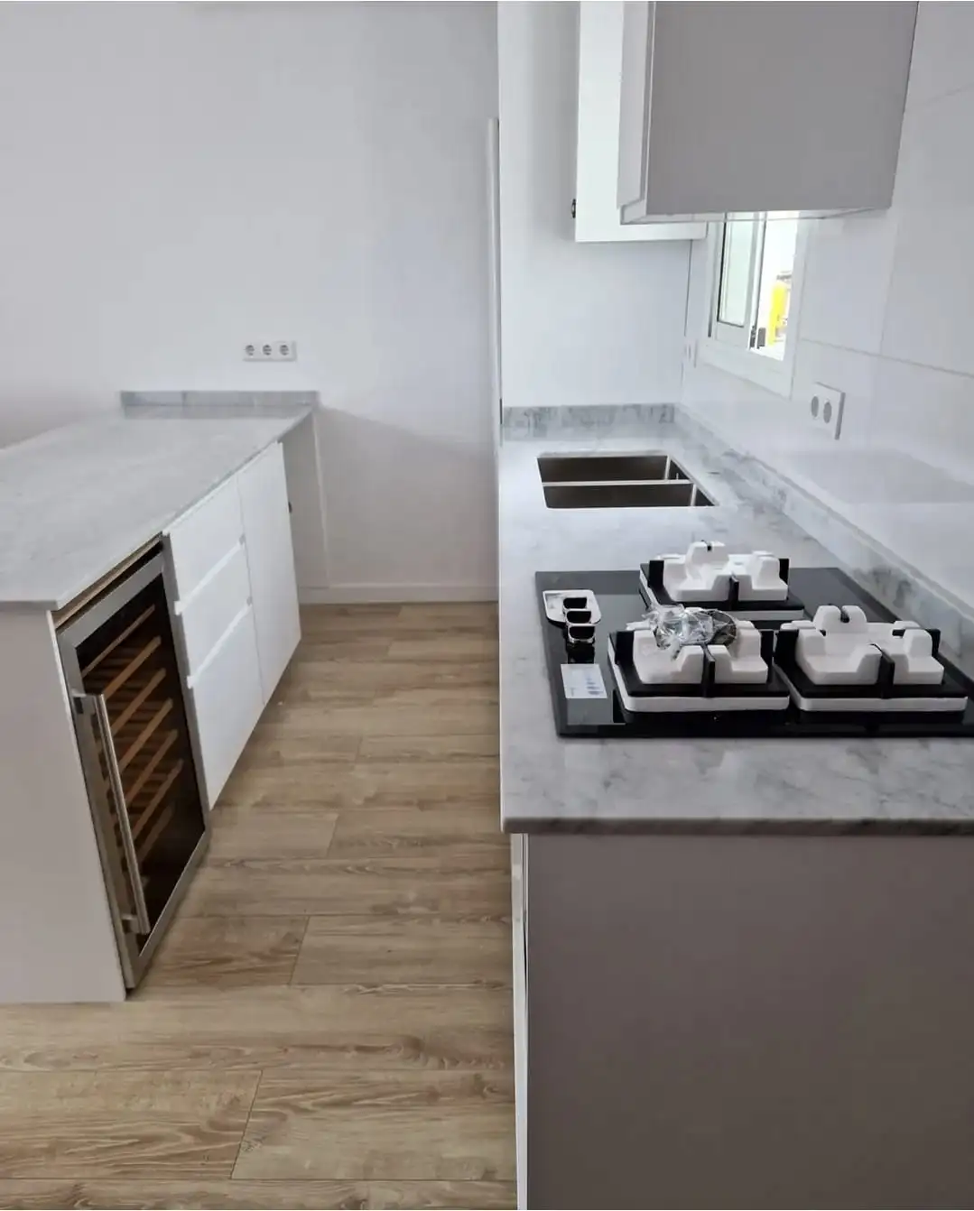 Cuina amb taulell de marbre de Carrara i vinoteca